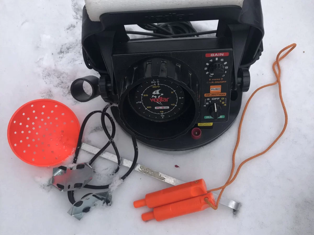 Vexilar, ice awls, ice cleats and skimmer on snow
