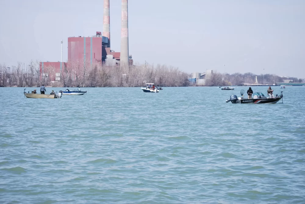 fishing boats on detroit river with power plant in background